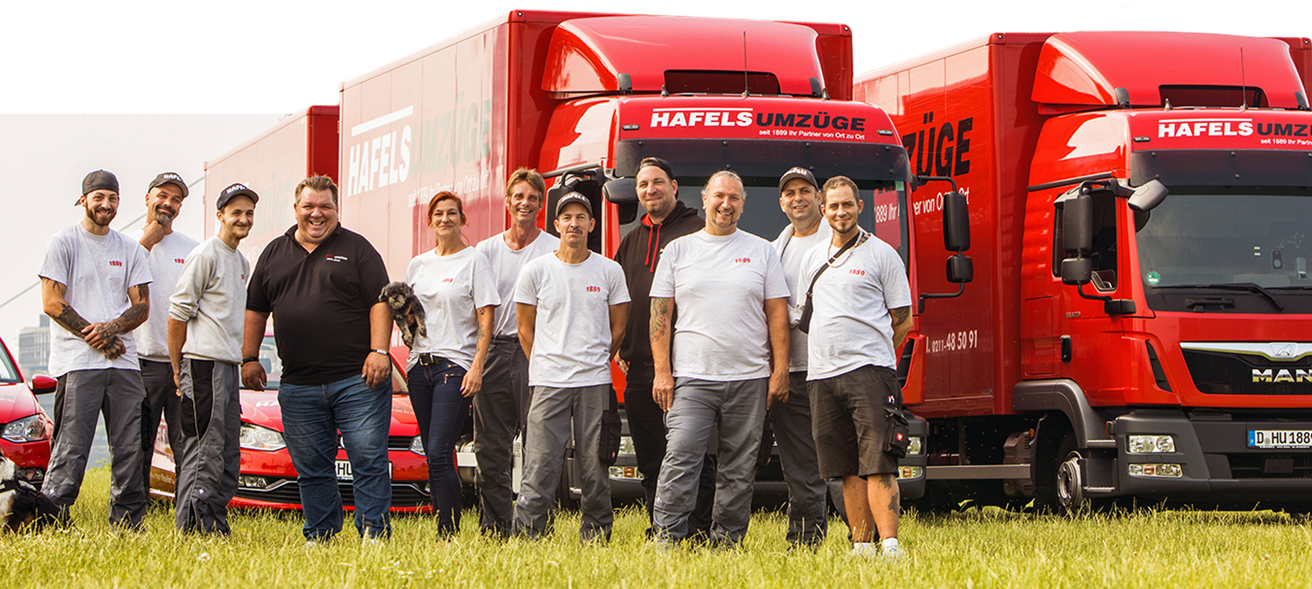 team Team von Hafels Umzüge vor 2 roten LKWs